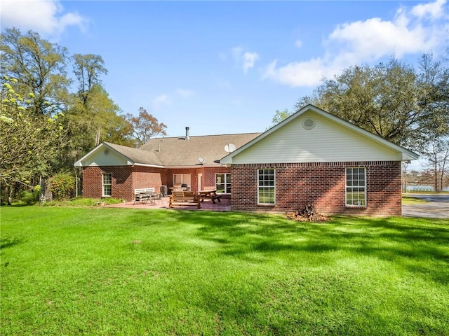 rear view of property with a lawn and a patio