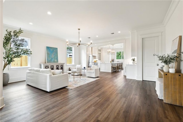 living room featuring a chandelier, dark hardwood / wood-style flooring, and crown molding