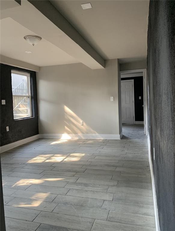 empty room featuring beam ceiling