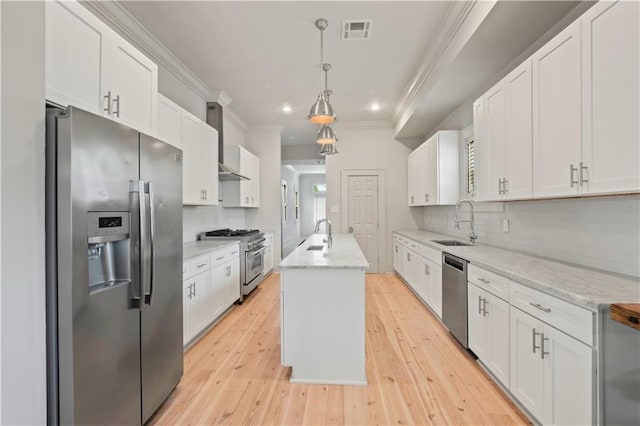 kitchen with an island with sink, stainless steel appliances, and white cabinetry