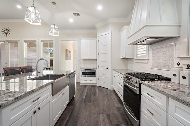 kitchen with premium range hood, tasteful backsplash, decorative light fixtures, white cabinetry, and stainless steel appliances