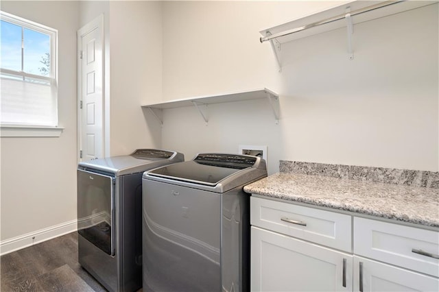 clothes washing area featuring cabinets, dark hardwood / wood-style flooring, and independent washer and dryer