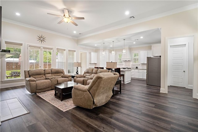 living room with ornamental molding, ceiling fan, and dark wood-type flooring