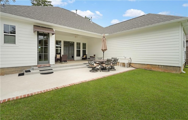 rear view of house featuring a lawn and a patio area