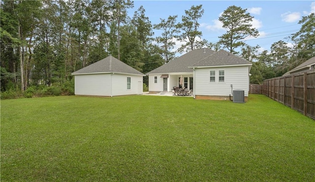 back of property featuring cooling unit and a yard