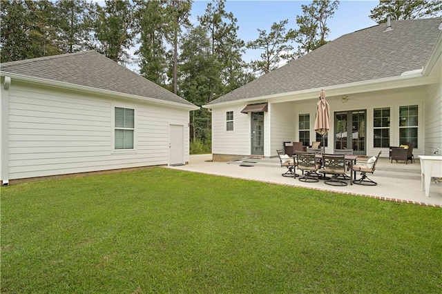 rear view of property with a lawn and a patio area