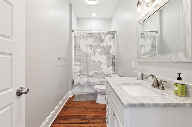 full bathroom with shower / tub combo with curtain, hardwood / wood-style floors, vanity, and toilet