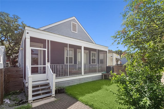 rear view of house with a sunroom and central AC