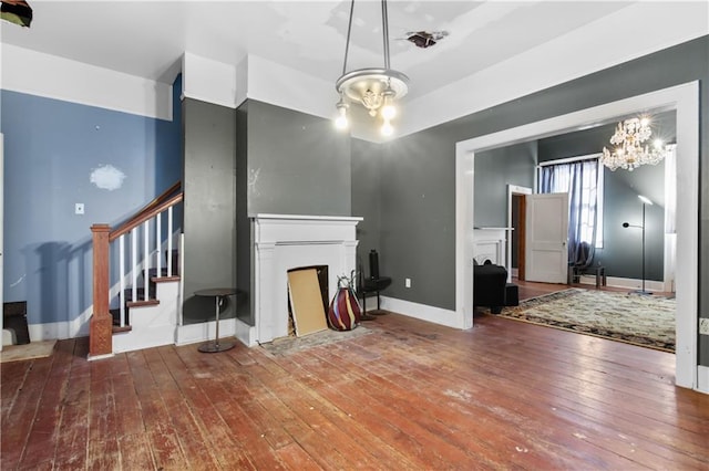 unfurnished living room with a chandelier and hardwood / wood-style flooring