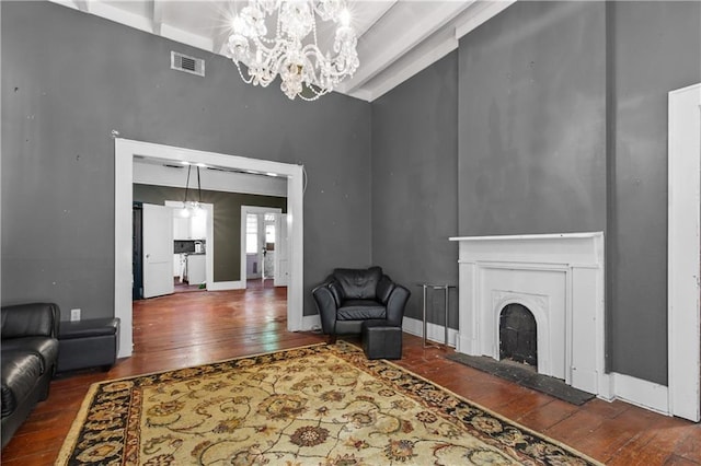 living room with high vaulted ceiling, an inviting chandelier, and dark wood-type flooring