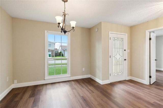 foyer entrance featuring an inviting chandelier and dark hardwood / wood-style floors