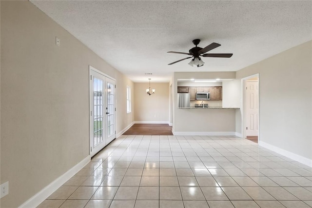 unfurnished living room with ceiling fan with notable chandelier, a textured ceiling, and light tile patterned floors