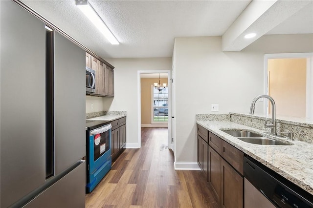 kitchen with light stone counters, stainless steel appliances, and sink