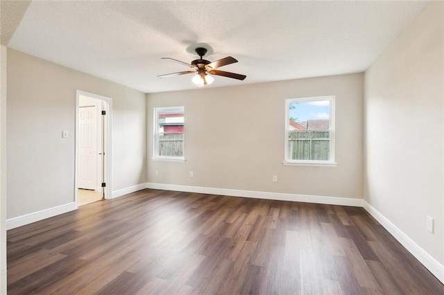 unfurnished room featuring ceiling fan, a textured ceiling, and dark wood-type flooring