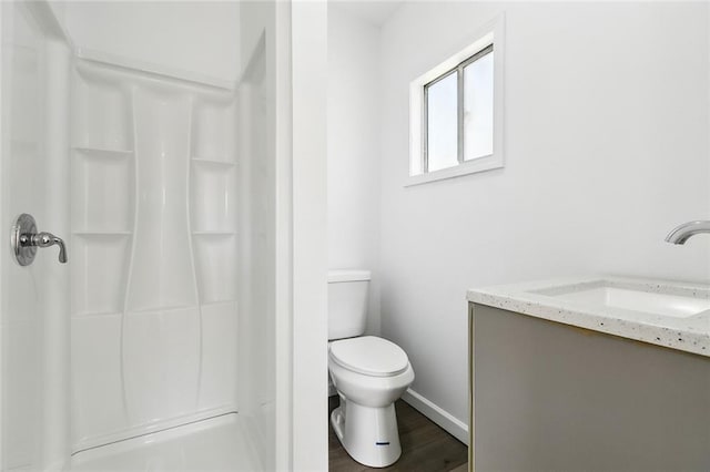 bathroom featuring walk in shower, vanity, toilet, and hardwood / wood-style flooring