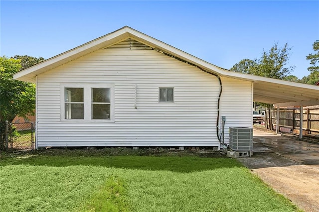 view of side of property with a carport, a lawn, and central air condition unit