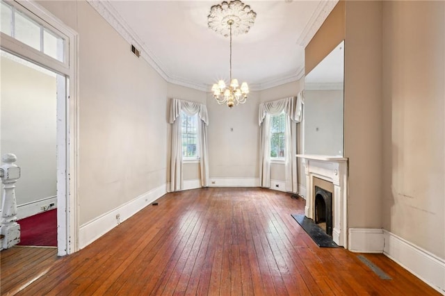 unfurnished living room featuring a premium fireplace, wood-type flooring, a notable chandelier, and ornamental molding