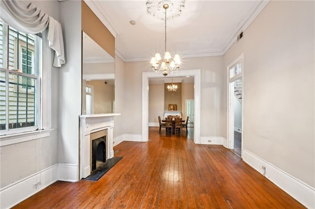 unfurnished living room with ornamental molding, hardwood / wood-style flooring, and a notable chandelier