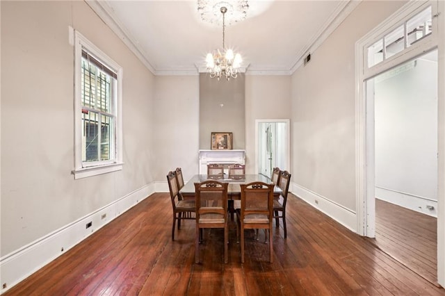 dining room with dark hardwood / wood-style flooring, crown molding, and a notable chandelier