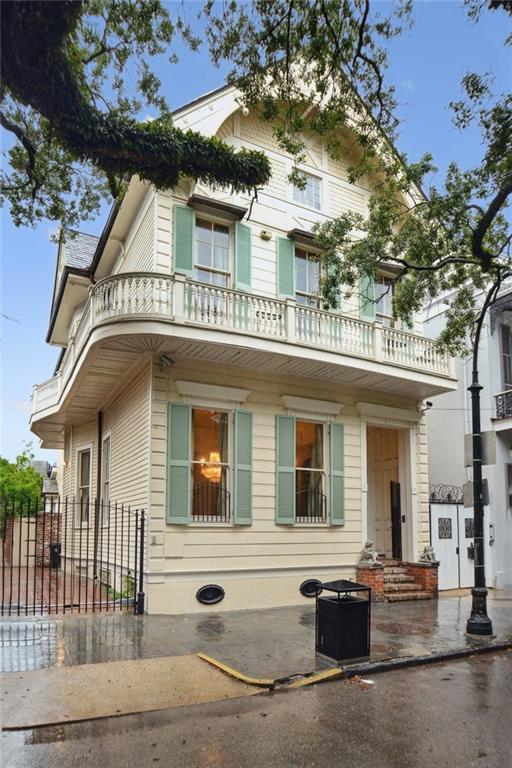 view of front of property featuring cooling unit and a balcony