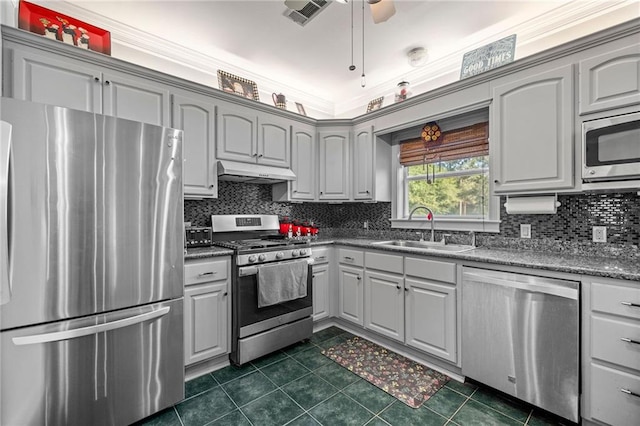 kitchen with dark tile patterned flooring, sink, decorative backsplash, appliances with stainless steel finishes, and ceiling fan