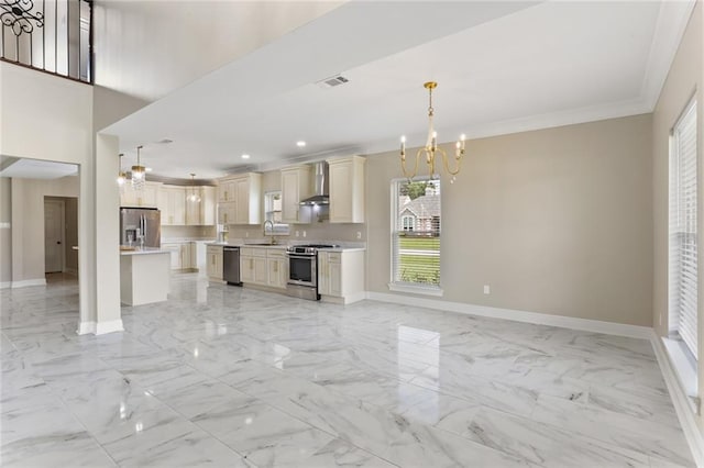 kitchen with sink, decorative light fixtures, wall chimney range hood, appliances with stainless steel finishes, and an inviting chandelier