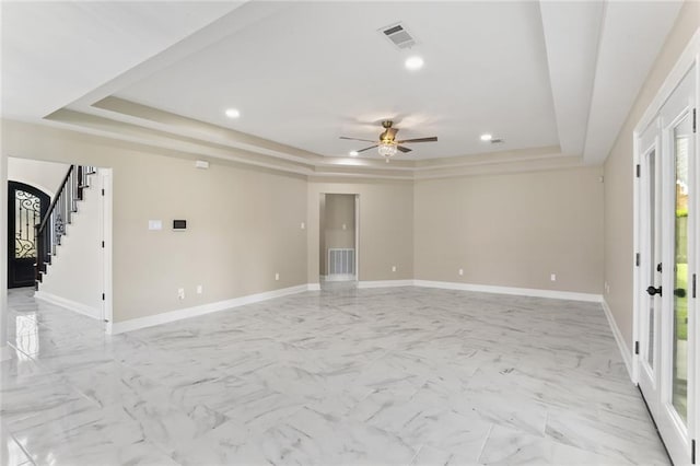 unfurnished room featuring ceiling fan and a tray ceiling