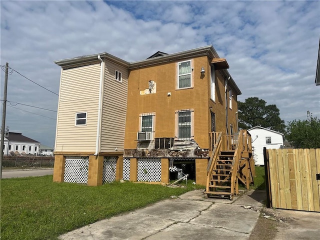 rear view of property featuring cooling unit and a lawn