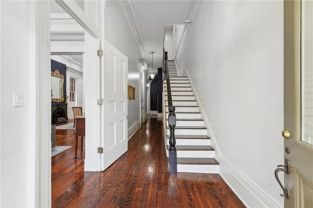 stairway with ornamental molding and hardwood / wood-style floors