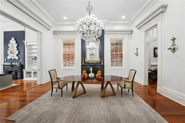 dining room featuring wood-type flooring, ornamental molding, and an inviting chandelier