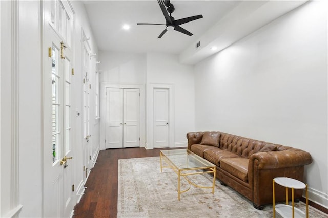 living room featuring dark wood-type flooring and ceiling fan