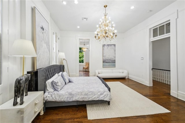 bedroom with an inviting chandelier and dark hardwood / wood-style floors