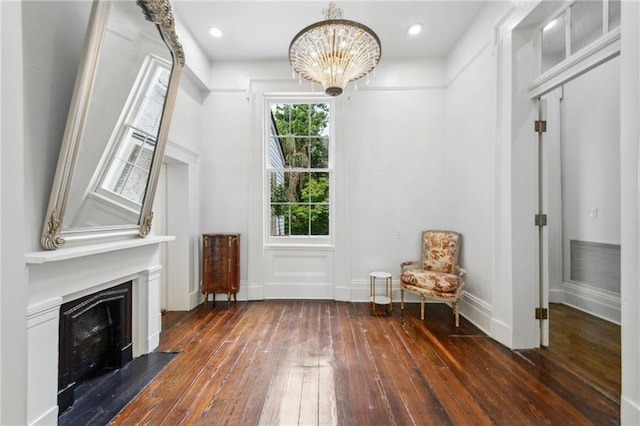 unfurnished room with an inviting chandelier and dark wood-type flooring