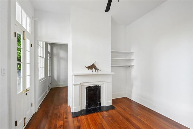 unfurnished living room featuring dark hardwood / wood-style floors, ceiling fan, and plenty of natural light