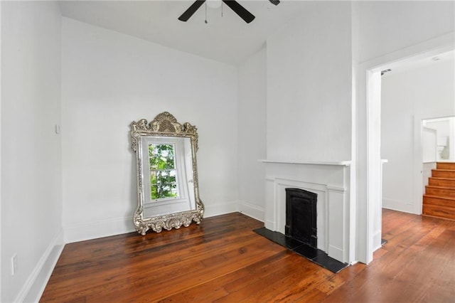 unfurnished living room with dark hardwood / wood-style floors and ceiling fan