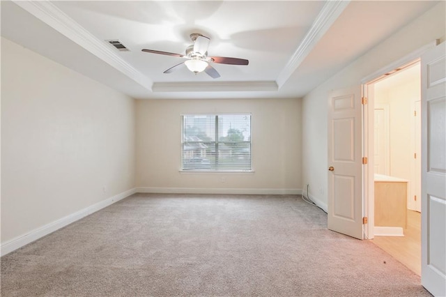 spare room featuring ornamental molding, light colored carpet, ceiling fan, and a raised ceiling