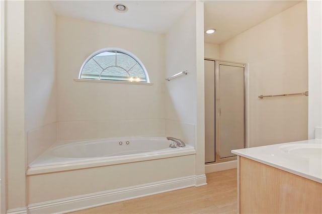 bathroom with independent shower and bath, vanity, and wood-type flooring