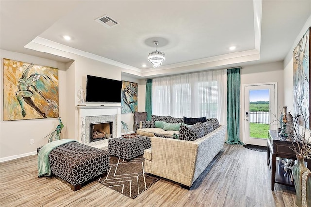 living room featuring wood-type flooring and a tray ceiling