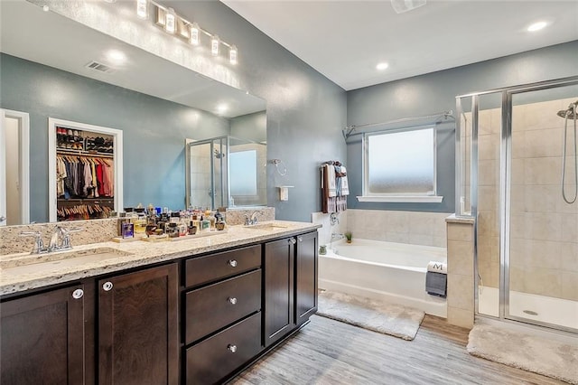 bathroom featuring independent shower and bath, hardwood / wood-style flooring, and vanity