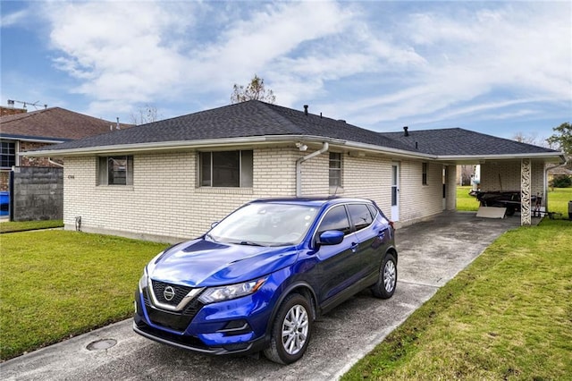 rear view of property with a carport and a yard