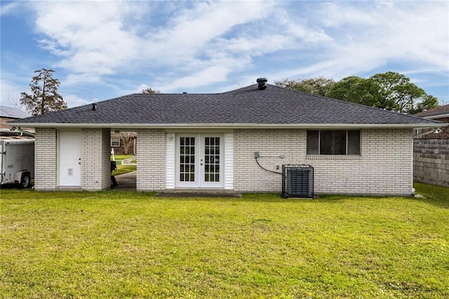 back of property featuring a lawn, central air condition unit, and french doors