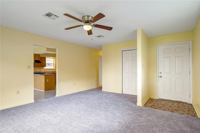 interior space with ceiling fan and light colored carpet