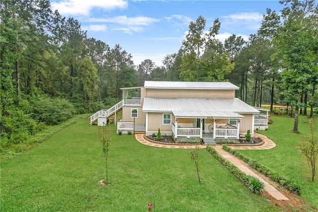 view of front facade featuring covered porch, metal roof, and a front lawn