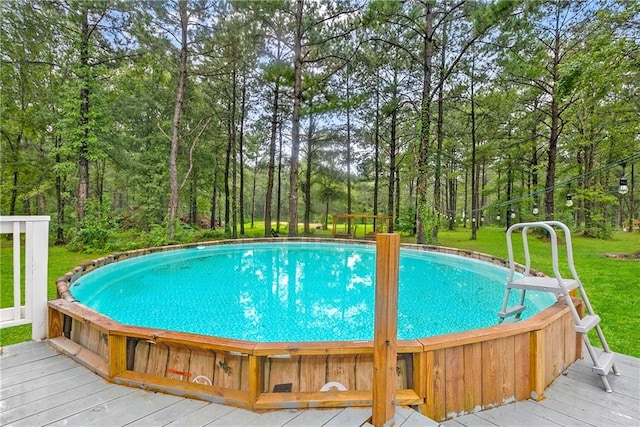 view of pool featuring a yard and a wooden deck