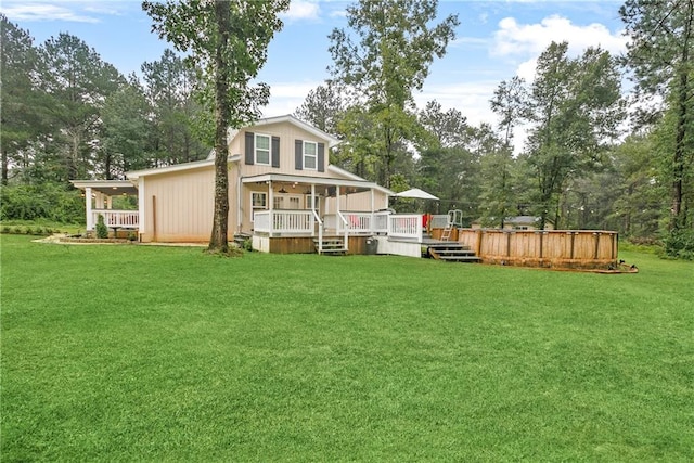 rear view of property featuring a wooden deck and a lawn