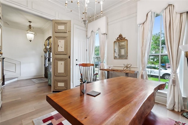 dining room featuring a chandelier, light hardwood / wood-style floors, and ornamental molding