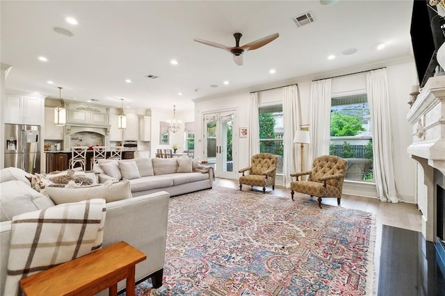 living room featuring hardwood / wood-style flooring, ceiling fan, and ornamental molding