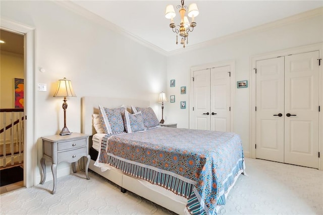 carpeted bedroom featuring a chandelier, multiple closets, and ornamental molding