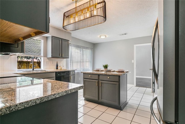 kitchen featuring stainless steel fridge, backsplash, black dishwasher, gray cabinets, and sink