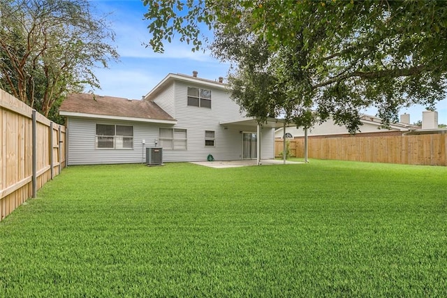 rear view of property with cooling unit, a yard, and a patio